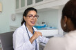 © fizkes - Smiling middle-aged physician consulting young African woman patient