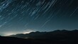 © MACHATOMI - A time-lapse style streak of stars moving across a dark night sky above a mountain range, cinematic composition