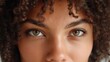 © 69 - Close-up Portrait of a Young Woman with Curly Hair and Beautiful Eyes Looking Directly at the Camera, Expressing Confidence and Serenity