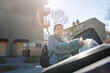 © Johnér - Portrait of smiling woman dumping garbage bag in bin at sunny day