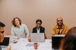 © Johnér - Multiracial male and female business professionals sitting in meeting room against wall at office