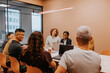 © Johnér - Group of multiracial business people sitting in illuminated meeting room of office