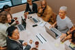 © Johnér - High angle view of male and female business professionals discussing strategies with each other in meeting room at office