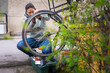© Johnér - Woman repairing wheel of commuting bike at street