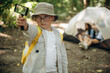 © standret - Rectangular magnifying glass in boy's hand. Happy kids are with tent in the forest