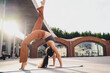 © BullRun - Athletic woman practicing advanced yoga inversion outdoors with arched back. Conceptual fitness image representing empowerment, mindfulness, resilience, strength, flexibility, and balanced lifestyle.