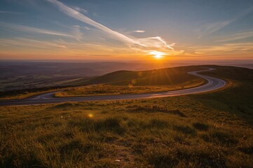 Wall Mural - Sunset over a twisting mountain road in a scenic upland area