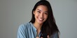 © Iryna - Smiling asian female young adult holding smartphone in casual attire