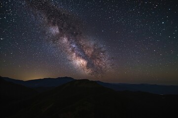Wall Mural - spectacular milky way stretches over rugged mountain peaks at a scenic viewpoint in northern thailan