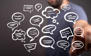 Stock photo of a man interacting with digital speech bubbles, representing communication, feedback, and online discussion.