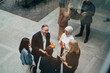 © Maskot - High angle view of happy businessman discussing with female corporate experts at networking event in convention center