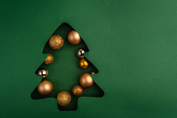 Wall Mural - a collection of gold and bronze christmas baubles arranged inside a green christmas tree cutout, cre