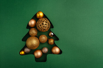 Wall Mural - a collection of gold and bronze christmas baubles arranged inside a green christmas tree cutout, cre