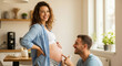© Vasiliy - Pregnant woman with partner in blue shirt at kitchen touching belly. Happy couple maternity moment for prenatal wellness and home lifestyle content