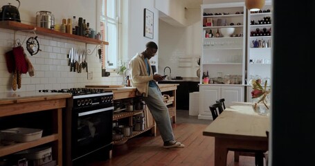 Break, phone and typing with black man in kitchen of home to search for recipe instructions online. App, communication and social media review with person in apartment for meal planning or research