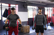 © Wavebreak Media - Diverse male gym partners lifting dumbbells, lowering weights in fitness studio with plyo box