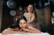 © dikushin - Closeup portrait of young woman lying with closed eyes in wellness center during massage therapy. Portrait of beautiful female client getting relaxing arm and shoulder massage in spa salon.