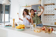 © Dorde - Young Women Friends Cooking and Singing Together in a Bright Modern Kitchen with Joyful Energy