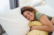 © Dorde - Smiling Woman Relaxing at Home with Yellow Patterned Pillow in Bright Cozy Living Room