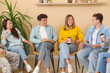 © Pixel-Shot - Young people with coffee cups sitting at group therapy session