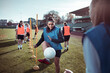 © Davor - Young woman practicing soccer drills with teammates on field