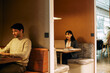 © Maskot - Female corporate business professional talking on video call through laptop while sitting in coworking office