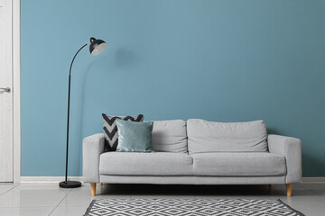 Wall Mural - Black lamp and sofa near green wall in living room