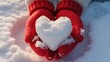 © Dream Studio - Hands in red knitted gloves holding a heart made of snow, a symbol of love and romance during the cold winter season