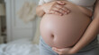 © Alexis - Portrait of a pregnant woman touching her big belly close up, mother, pregnancy, people and expectation. Woman holding big pregnant stomach
