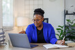 © David - African American business woman, A female secretary work on laptop Sitting at a Desk, reports to the workplace in the office, uses a computer