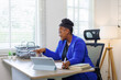 © David - African American business woman, A female secretary work on laptop Sitting at a Desk, reports to the workplace in the office, uses a computer