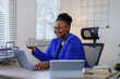© David - African American business woman, A female secretary work on laptop Sitting at a Desk, reports to the workplace in the office, uses a computer