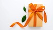 © fantasy - Gift box with ribbon and green leaves on a white background. Top-down view. The ribbon is orange. Clean, bright and minimalist composition