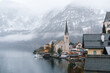 Close-up view of Hallstatt church and lakeside buildings under winter fog