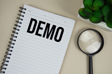 Demo text on paper notebook with magnifying glass on beige leather background