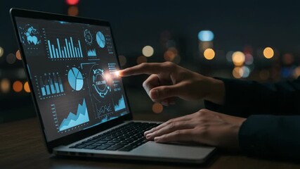 Person interacting with futuristic data visualization on laptop at night