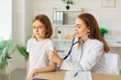 © Studio Romantic - Friendly female child doctor pediatrician examining little boy patient with stethoscope standing on workplace in medical clinic in exam room during checkup. Pediatrics and medicine concept