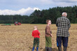 © Natallia - Two generations of grandchildren and grandfather in a farmer's field