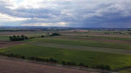 Wall Mural - Czech landscape of fields and meadows from a drone view. Cloudy sky with clouds and villages in the distance