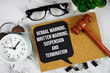 © may1985 - Verbal Warning, Written Warning, Suspension and Termination text on speech bubble with alarm clock and wooden gavel on marble background