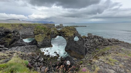 Wall Mural - Cloudy view of rocky coastline in Arnarstapi, Iceland.