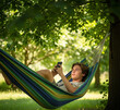 © Metehan - young man or boy with mobile phone in summer lying in hammock
