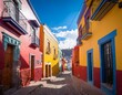 colorful houses in a cobblestone alley in guanajuato mexico under a blue sky