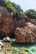 A picturesque rocky coastal landscape features rugged formations