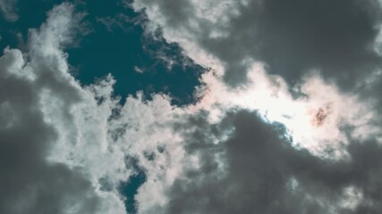 Wall Mural - Sunray Shine Through Dark Clouds In Cloudy Blue Sky. Natural Background Clouds Time Lapse. Cloudy Sky With Fluffy Clouds. Dark Clouds Disperse And Clear Skies Appear. Sun Shines Directly Into Eyes