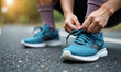 © AlenaSi - Tying shoelaces on running shoes during school sport training in natural light. Tying shoelaces ensures safety while doing school sport and jogging on track.