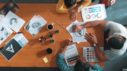 Top view of manager writing idea on sticky notes and explain idea about web design. Professional marketing team or programmer brainstorming idea while looking at tablet with color palette. Symposium.
