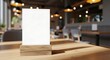 © Anik Sarker - Blank white menu holder on wooden base in cozy restaurant setting