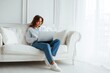 © LimeSky - Tech freelancing and individuals idea young woman on a white couch using a laptop
