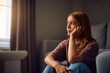© Drazen - Sad woman thinking of something at home.